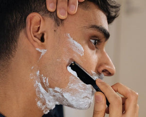 man-shaving-with-black-straight-razor
